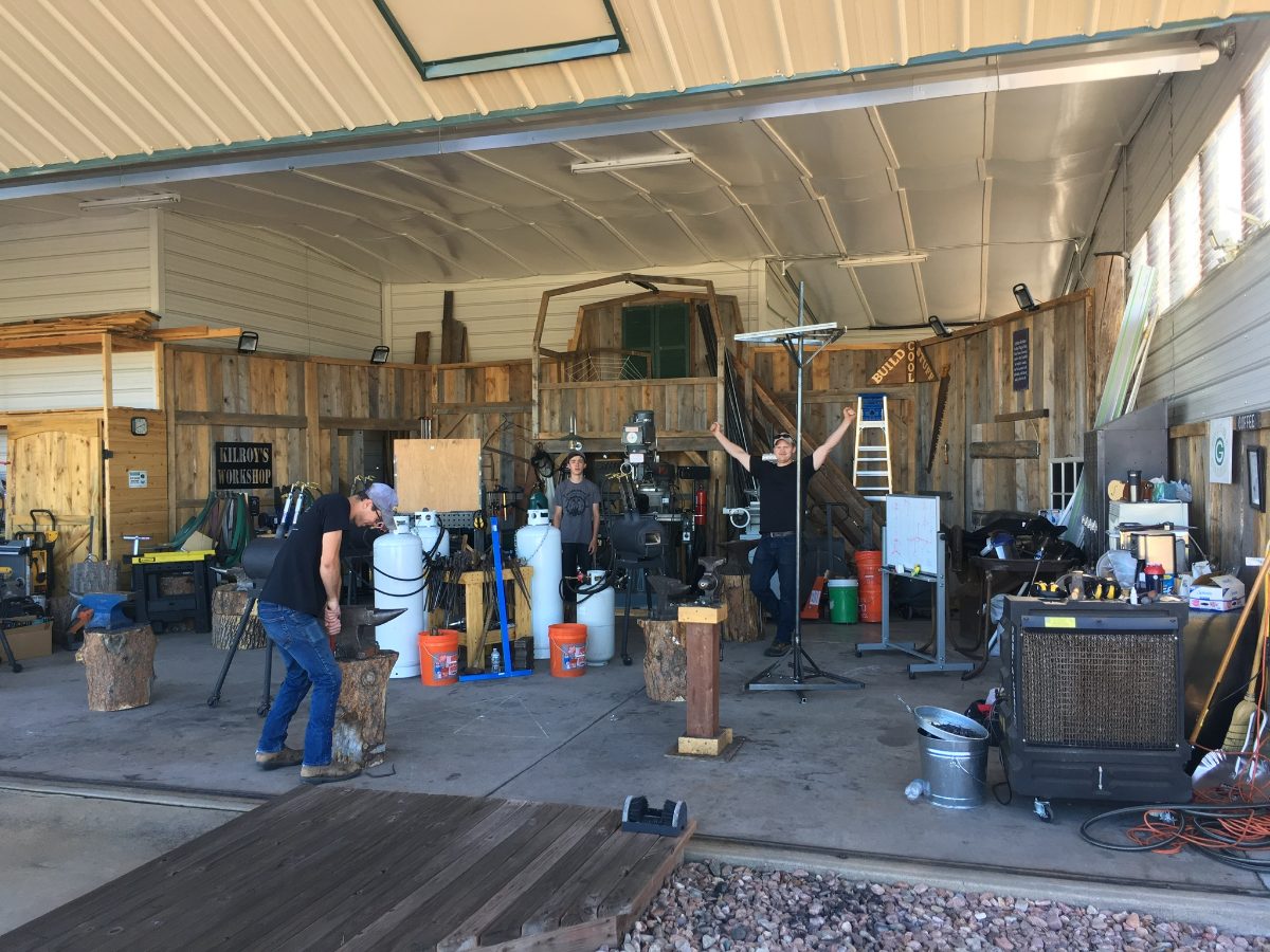 People gathered among workbenches and equipment at Kilroy’s Workshop.